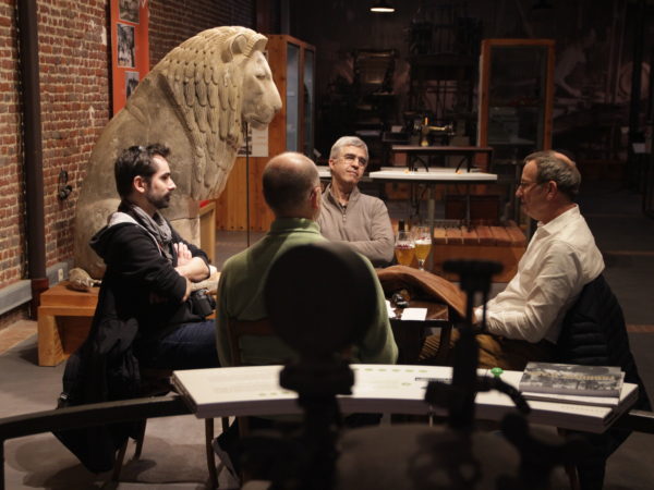 4 personnes sont assises autour d'une table dans le musée. Elles discutent de leur travail.