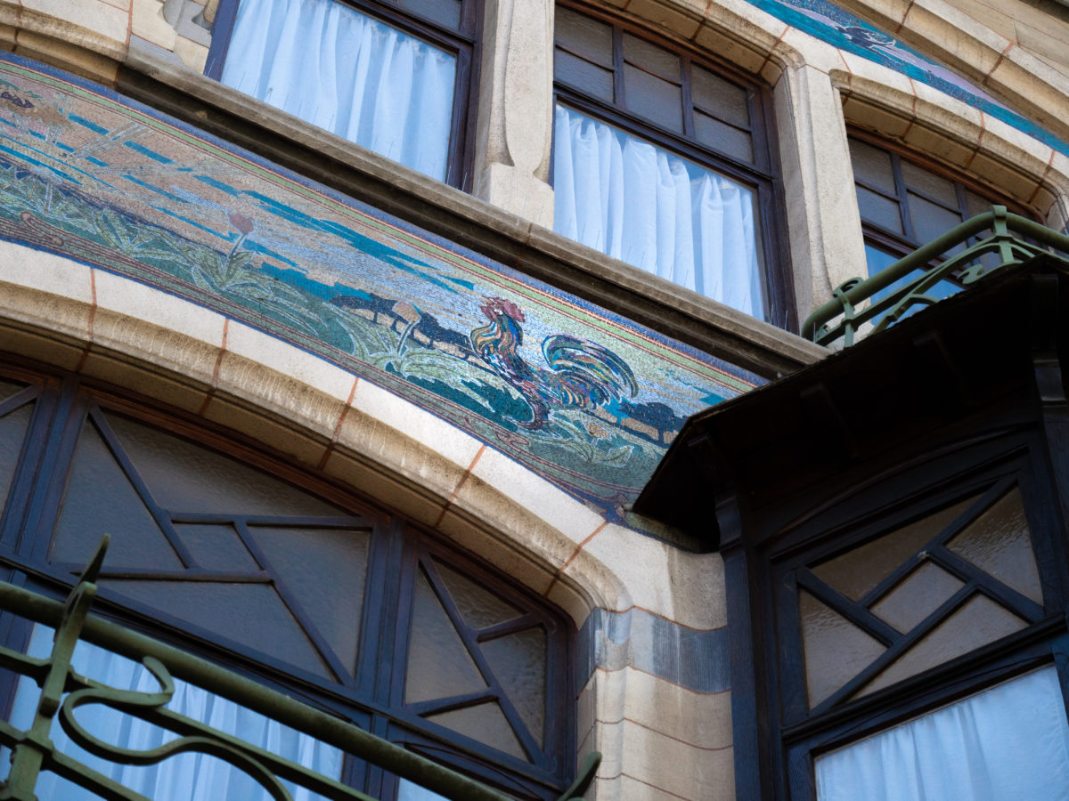 façade d'une maison à l'architecture art nouveau. Elle présente le sgrafitte d'un coq et une balustrade en fer forgé
