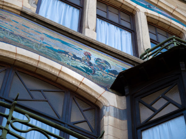 façade d'une maison à l'architecture art nouveau. Elle présente le sgrafitte d'un coq et une balustrade en fer forgé
