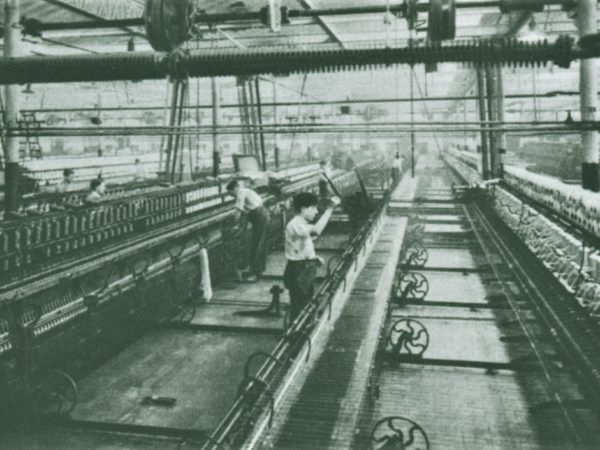 Ouvriers travaillant sur des machines dans une usine de filature de laines