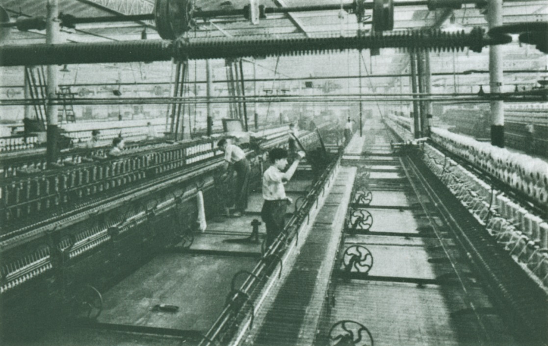 Ouvriers travaillant sur des machines dans une usine de filature de laines