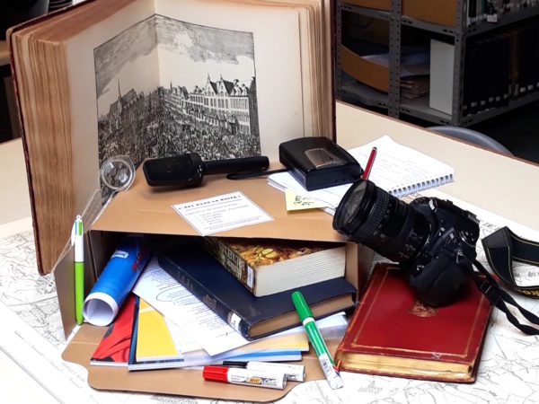 Boîte de centre documentation avec en vrac : livres, revues, brochures, carnet d enotes, bics, loupe, feutres, enregistreur, micro et appareil photo...