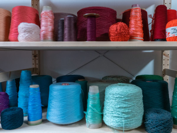 Des bobines de fils de couleur attendent d'être intégrées à un nouveau tissage.