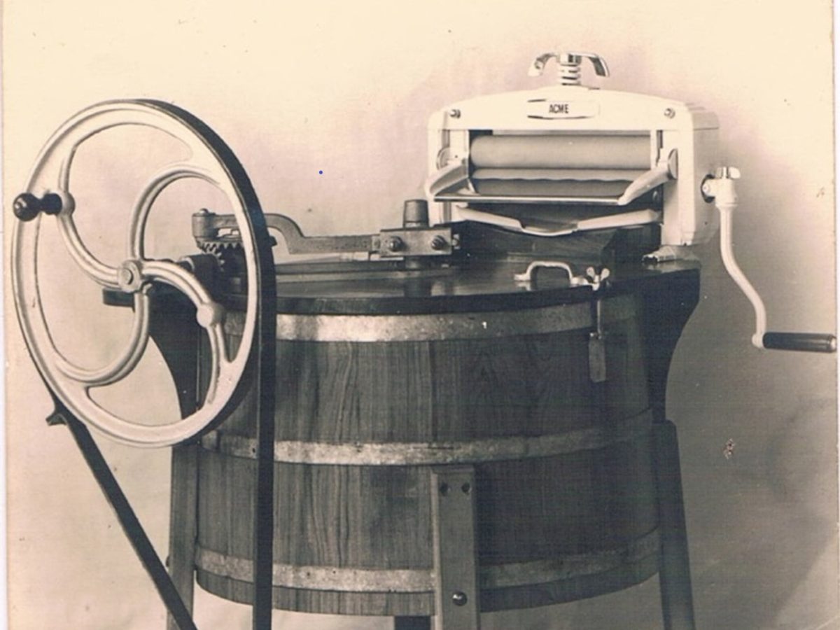 Ancienne photo d'une machine à laver avec moteur électrique et essoreuse.